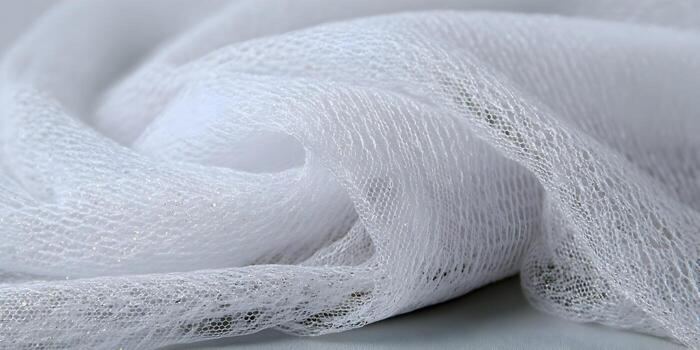 A delicate white sheer fabric with shimmering glitter is draped softly creating a textured abstract background photo