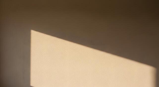 Abstract interplay of bright sunlight and deep shadows across a textured, warm-toned wall, forming captivating geometric patterns and a serene, minimalist atmosphere photo