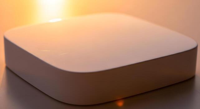 Sleek, modern white electronic device with rounded edges, illuminated by a soft, warm glow, symbolizing contemporary technology, innovation, and seamless connectivity in a minimalist setting photo