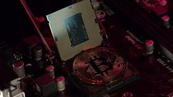 Bitcoin mining. BTC and CPU central processor on the digital technology pc motherboard. Market trading cashless e-commerce. Gold bitcoin crypto currency isolated on computer board. New virtual money video