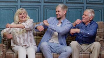 glücklich Generation Familie von Senior Großeltern mit Erwachsene Sohn Hören zu Musik, dumm Tanzen, haben Spaß, albern. Mann mit Oma und Großvater, liebend Mutter Vater Verbindung beim Zuhause auf Sofa video
