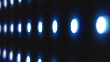 Blue illuminated circles in a grid pattern glowing over a dark surface video
