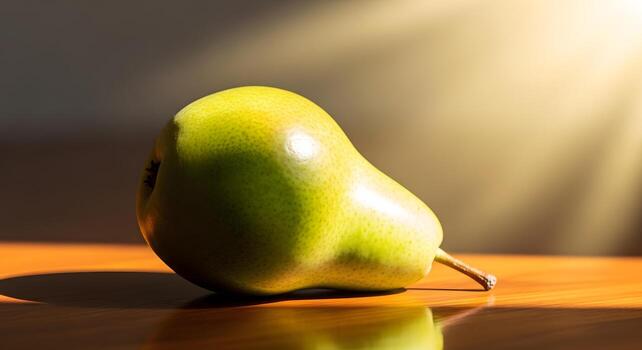 A close-up, sunlit image of a single, ripe green pear resting on a polished wooden surface, casting a soft shadow photo