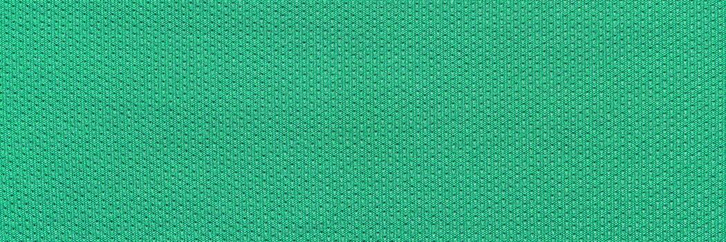 Green textured fabric pattern with diamond shapes in a close-up view showing detailed weave design. photo