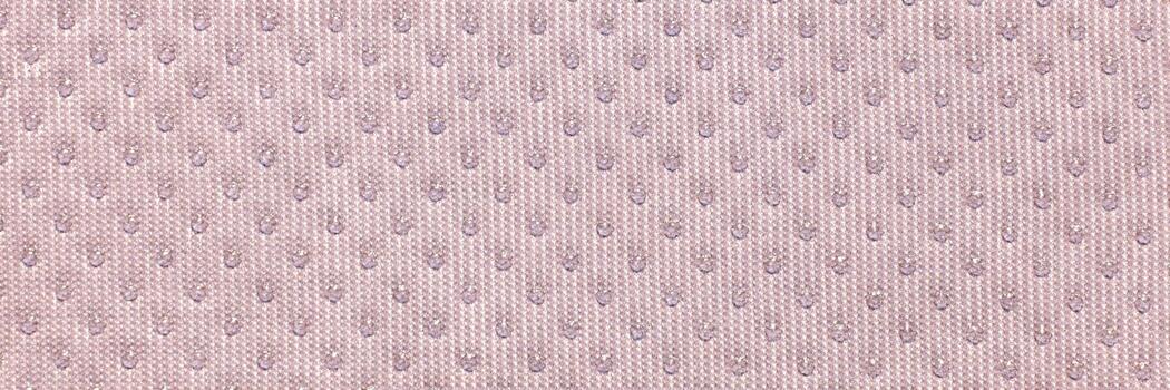 Textured beige fabric close-up with subtle pattern of small dots creating elegant surface design. photo