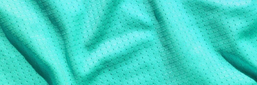 Teal textured fabric with geometric patterns and subtle shadows creating depth. photo