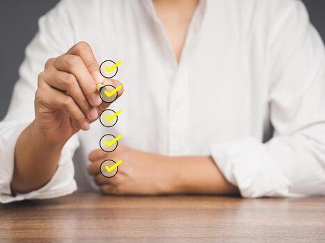 Close-up of a businessman use a pen to tick the correct sign mark in the checkbox while sitting. photo