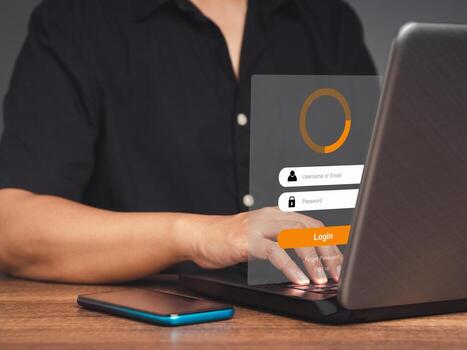 Businessman login to the network by username and password on the virtual screen while sitting at the table in the office photo