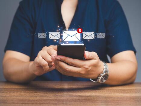 Close-up of a businessman using a mobile receive a new message with email icons while sitting. photo