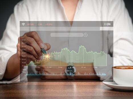 Close-up of a businessman or trader pointing to a graph stock on a virtual screen photo