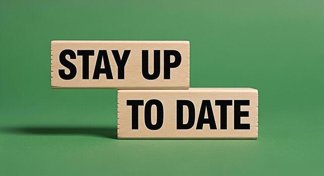 Wooden blocks displaying the message Stay Up To Date against a vibrant green backdrop symbolizing the importance of continuous learning and adaptation in a rapidly evolving world fostering a sense of photo