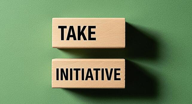 Wooden blocks on a green surface displaying the message Take Initiative symbolizing proactive leadership and a positive mindset towards achieving goals in a business or personal development context photo