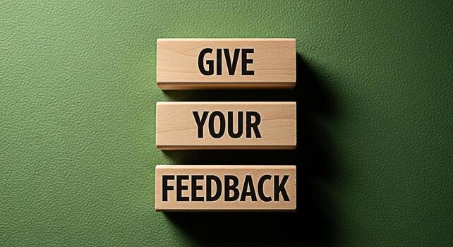 Wooden blocks stacked on a green textured surface displaying the message Give Your Feedback in bold letters symbolizing the importance of customer opinions and constructive criticism in a business set photo