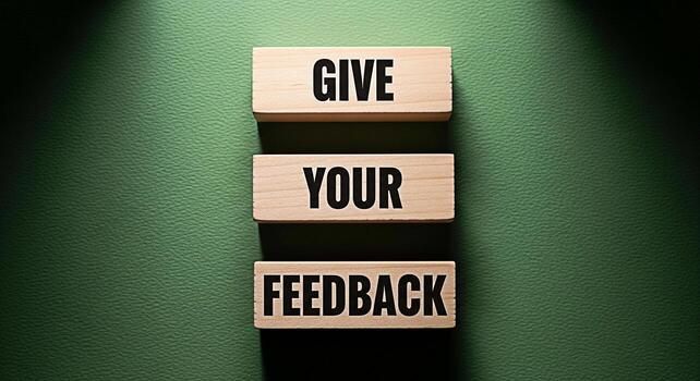 Wooden blocks on a textured green surface spelling out Give Your Feedback under a spotlight promoting customer engagement and business improvement through valuable insights and open communication photo