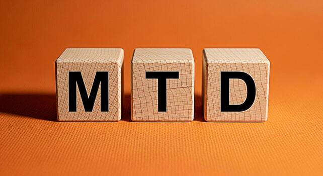 Three wooden blocks displaying MTD on an orange textured surface representing month to date financial performance offering a clear and concise visual for business and accounting concepts photo