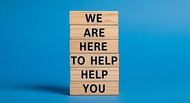 Wooden blocks stacked high on a vibrant blue background displaying the message We are here to help you conveying a sense of support assistance and a welcoming atmosphere for customers and clients photo