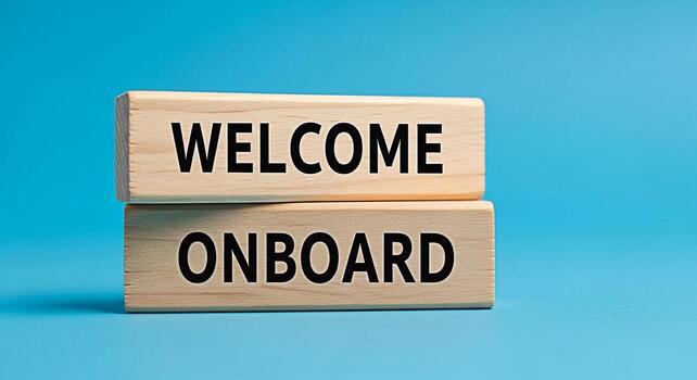 Wooden blocks stacked on a blue surface displaying Welcome Onboard symbolizing a positive and inviting atmosphere for new team members joining a company or organization fostering a sense of belonging photo