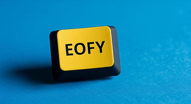 Closeup of a yellow computer key displaying EOFY on a blue textured surface representing the end of financial year symbolizing deadlines accounting and fiscal responsibility in a business environment photo