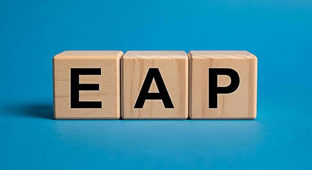 Wooden blocks displaying EAP on a blue surface representing Employee Assistance Program in a supportive and professional environment emphasizing wellbeing and resources for employees photo