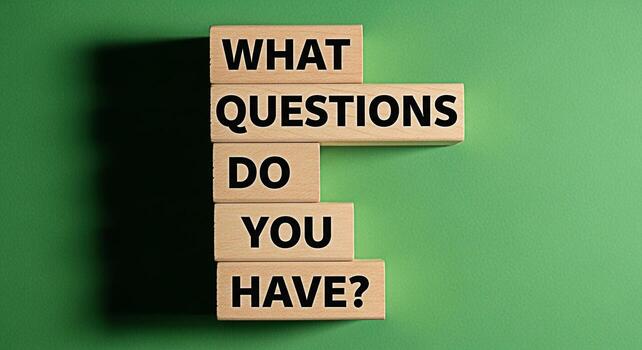 Wooden blocks spelling What Questions Do You Have arranged on a green background representing inquiry curiosity and the pursuit of knowledge in an educational or problemsolving context photo