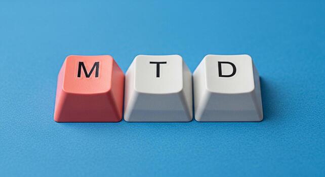 Closeup of three computer keycaps displaying the letters M T and D on a blue textured surface representing month to date financial reporting and business performance analysis with a clean and modern a photo