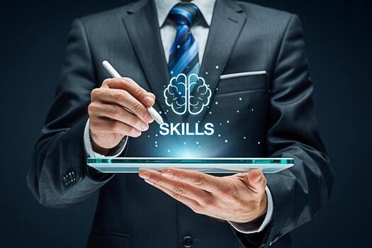 Sharp dressed businessman using a stylus on a tablet to enhance skills set against a dark backdrop symbolizing professional development and the acquisition of new competencies in a modern business env photo