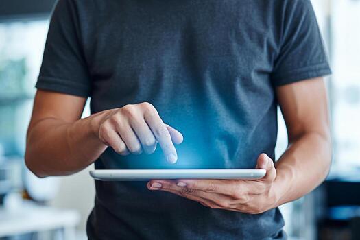 Focused man in a casual setting using a digital tablet with a glowing screen showcasing modern technology and connectivity symbolizing innovation and efficiency in the digital age with a touch of futu photo
