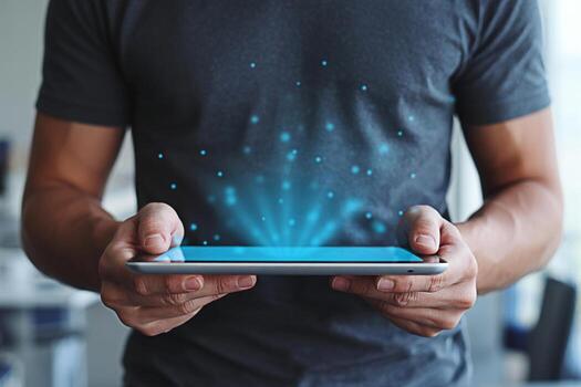 Man holding a tablet with glowing blue light emanating from the screen in a bright modern office symbolizing innovation technology and the future of digital communication and data visualization photo