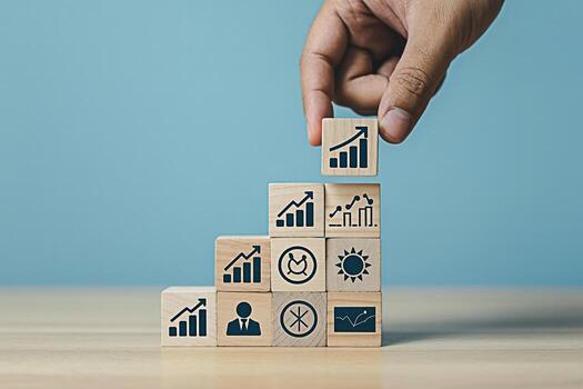 Hand placing a wooden block with a graph icon on top of a stack of cubes representing growth and success in a bright and optimistic business environment symbolizing progress and achievement photo
