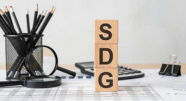 Wooden blocks displaying SDG on a desk with financial reports calculator and stationery symbolizing sustainable development goals and a commitment to global progress in a professional setting photo