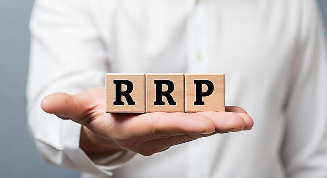 Closeup of a hand presenting wooden blocks spelling RRP against a neutral background symbolizing retail price strategy and consumer value emphasizing transparency and informed purchasing decisions photo