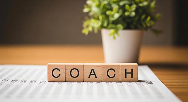 Wooden blocks spelling COACH rest on a financial report in a bright office symbolizing guidance and mentorship in business fostering a supportive and growthoriented environment for professional develo photo