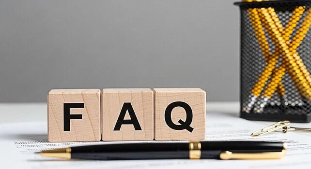 Wooden blocks displaying FAQ on a white desk with a pen and pencil holder representing frequently asked questions and providing information in a professional and helpful environment fostering clarity photo