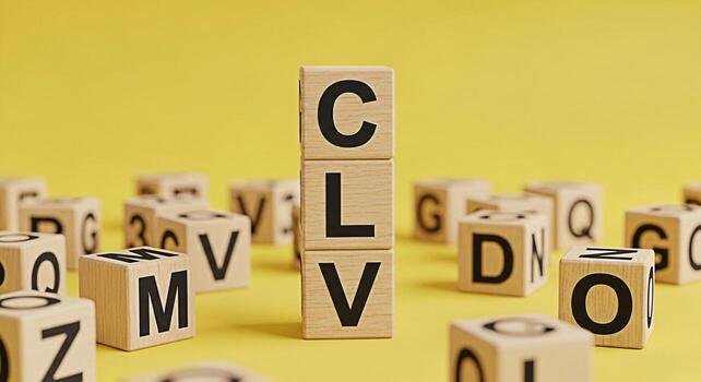 Wooden blocks spelling CLV stacked high on a yellow surface surrounded by scattered alphabet blocks representing customer lifetime value and strategic business growth with a bright optimistic mood photo