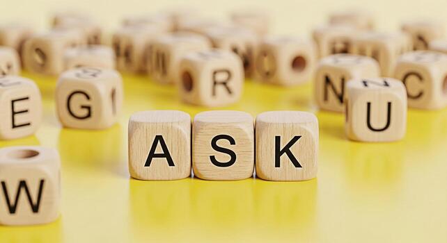 Wooden alphabet blocks spelling ASK on a yellow surface encouraging questions and curiosity in an educational and playful environment promoting learning knowledge and the importance of seeking informa photo