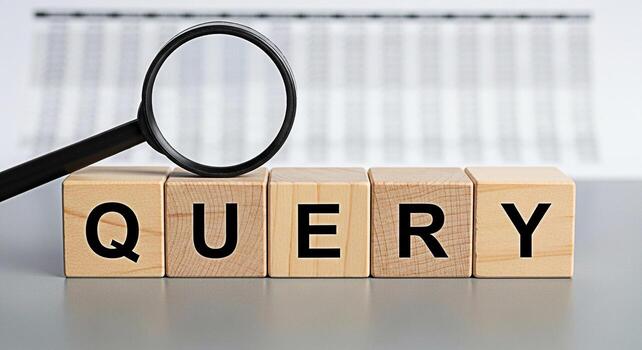 Magnifying glass analyzing the word QUERY spelled out on wooden blocks placed on a gray surface against a blurred spreadsheet background representing data analysis and information retrieval with a foc photo