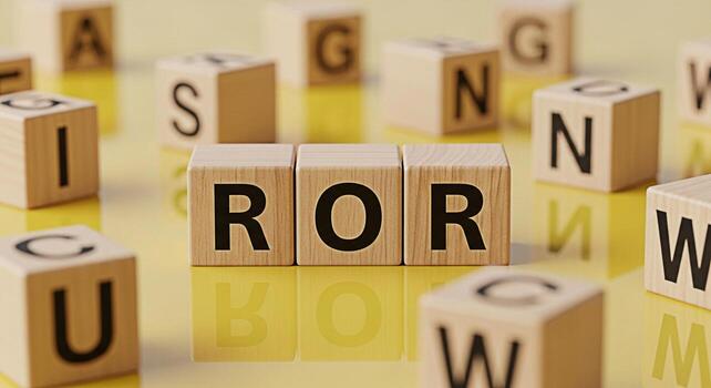 Wooden blocks spelling ROR on a reflective yellow surface surrounded by other letter blocks symbolizing Return on Risk and investment strategy in a bright optimistic financial environment photo