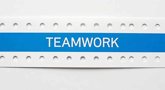 de cerca de el palabra trabajo en equipo desplegado prominentemente en un azul bandera con un blanco perforado frontera simbolizando colaboración y unidad en un limpiar moderno ajuste Fomentando un sentido de camaradería y sh foto