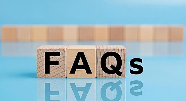 Wooden blocks displaying FAQs on a reflective blue surface representing frequently asked questions and information resources conveying clarity and support in a modern minimalist setting photo