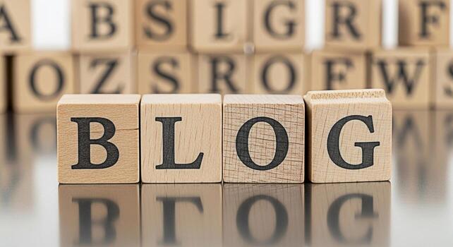 Wooden blocks spelling out BLOG on a reflective surface surrounded by other letter blocks representing the concept of online writing content creation and digital communication in a bright and minimali photo