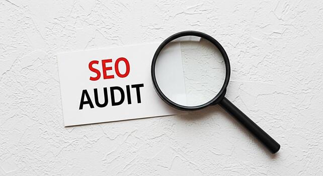 Magnifying glass inspecting an SEO Audit document on a textured white surface symbolizing detailed analysis and optimization for search engine ranking and online visibility creating a sense of thoroug photo