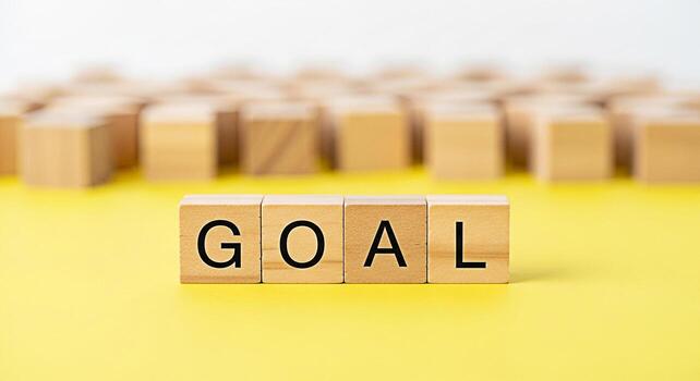 Wooden blocks spelling out GOAL on a bright yellow surface symbolizing ambition and achievement with a blurred background of additional blocks suggesting a network of objectives and a focused determin photo