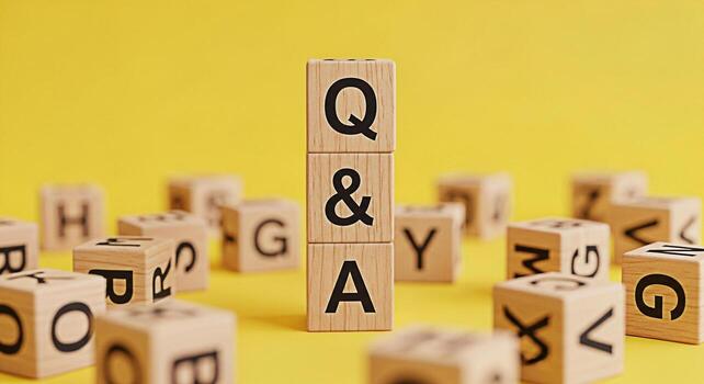 Wooden blocks displaying Q A stand prominently on a bright yellow background surrounded by scattered alphabet blocks creating a playful and informative atmosphere ideal for educational or business con photo