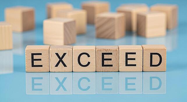 Wooden blocks spelling EXCEED on a reflective blue surface symbolizing surpassing expectations and achieving success in a competitive business environment fostering a sense of motivation and aspiratio photo