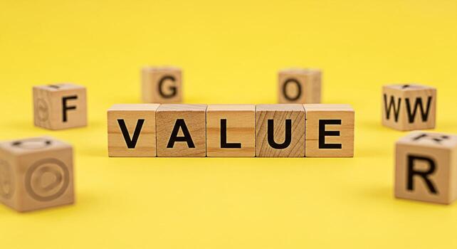 Wooden blocks spelling VALUE on a bright yellow background representing core values and business principles conveying a message of importance integrity and ethical considerations in a companys mission photo