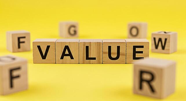 Wooden blocks spelling VALUE on a bright yellow background surrounded by blocks with letters forming GROW FURTHER and FOR representing growth advancement and positive values in a conceptual setting photo