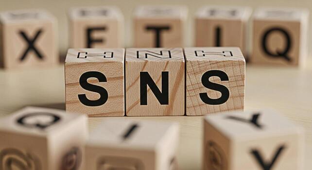 Wooden blocks spelling SNS on a light wooden surface surrounded by other lettered blocks representing social networking services and online communication in a simple and minimalist setting conveying c photo