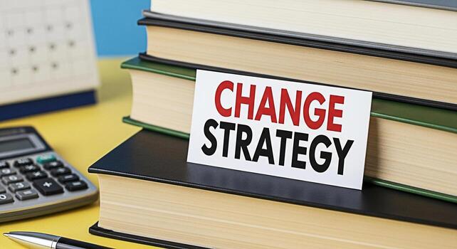 Closeup of a stack of books with a card displaying Change Strategy in a bright office setting symbolizing business transformation adaptation and the importance of strategic planning for success photo