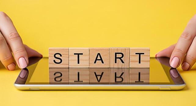 Female hands touching a tablet displaying wooden blocks spelling START on a vibrant yellow background symbolizing a fresh beginning and the motivation to launch a new project or business venture photo