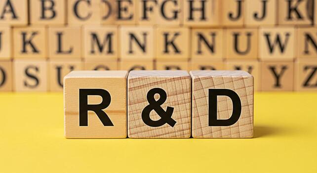 Wooden blocks displaying RD on a yellow surface surrounded by alphabet blocks symbolizing research and development in a learning environment fostering innovation and knowledge creation photo